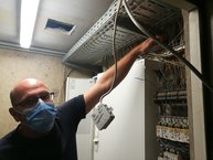 Schmidt deutet den Wasserstand an, unter seinem Arm liegen strom- und Verteilerkästen.