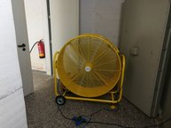 Ein großes Gebläse steht im Kellerflur, circa einen Meter hoch.