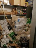 Einer der Lagerräume, Klopapier, Getränkekästen, Klopapierrollen sind von den Regalen gekippt, alles liegt kreuz und quer. Alles ist schlammig.