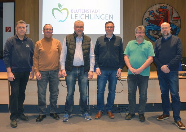 Die Bürgersolarberater stehen im großen Ratssaal aufgestellt und lächeln in die Kamera, im Hintergrund prangt das Leichlinger Wappen und das Stadtlogo.